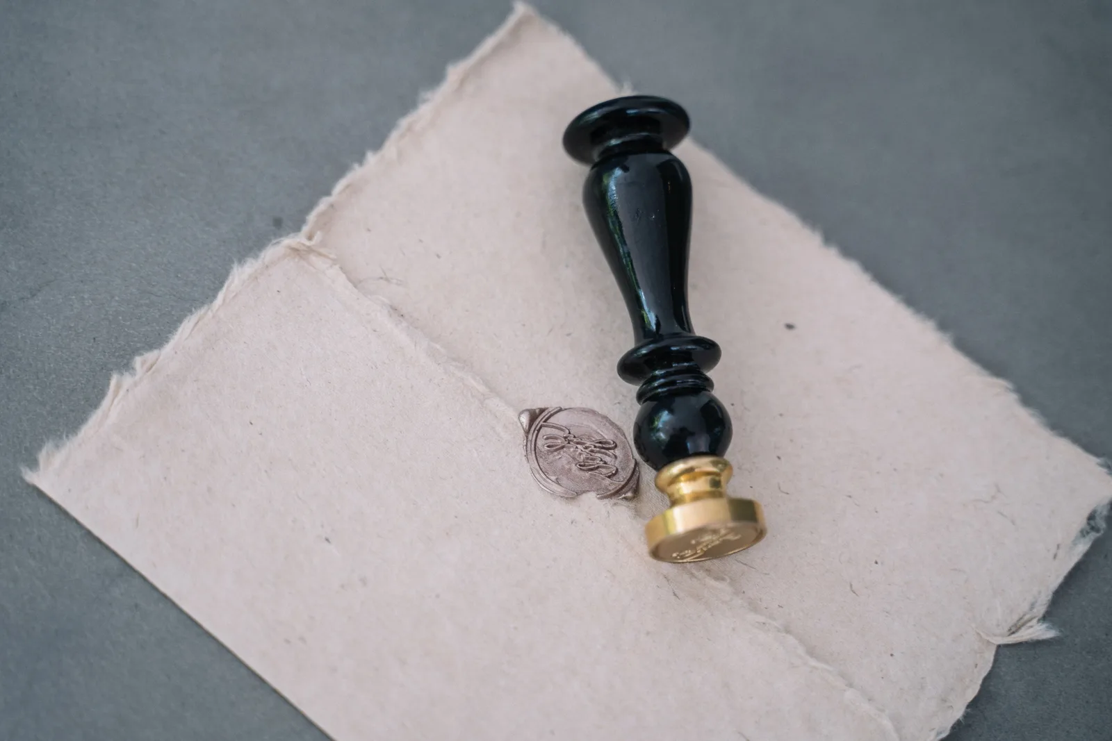 Close-up of a vintage wax seal on a rustic paper envelope with a black sealing stamp. Mobile notary bundles and pricing tiers in 2027