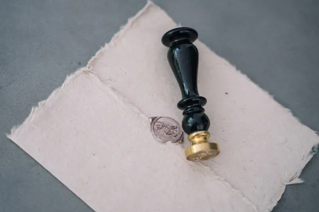 Close-up of a vintage wax seal on a rustic paper envelope with a black sealing stamp. Mobile notary bundles and pricing tiers in 2027