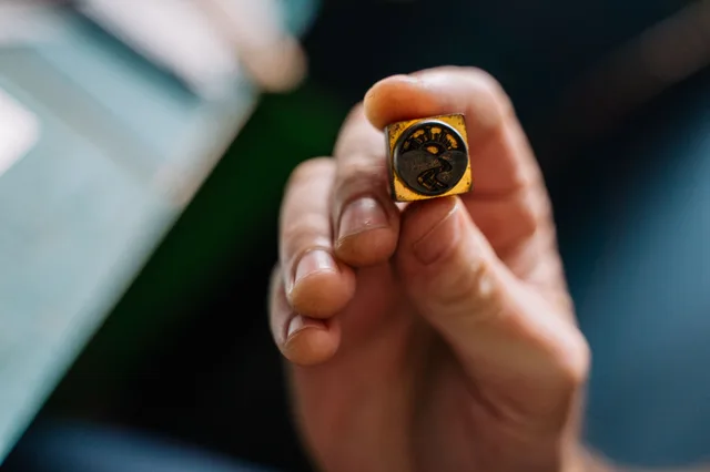 Detailed view of a handcrafted wax seal stamp held in hand, showcasing intricate design. Mobile notaries: the questions that matter