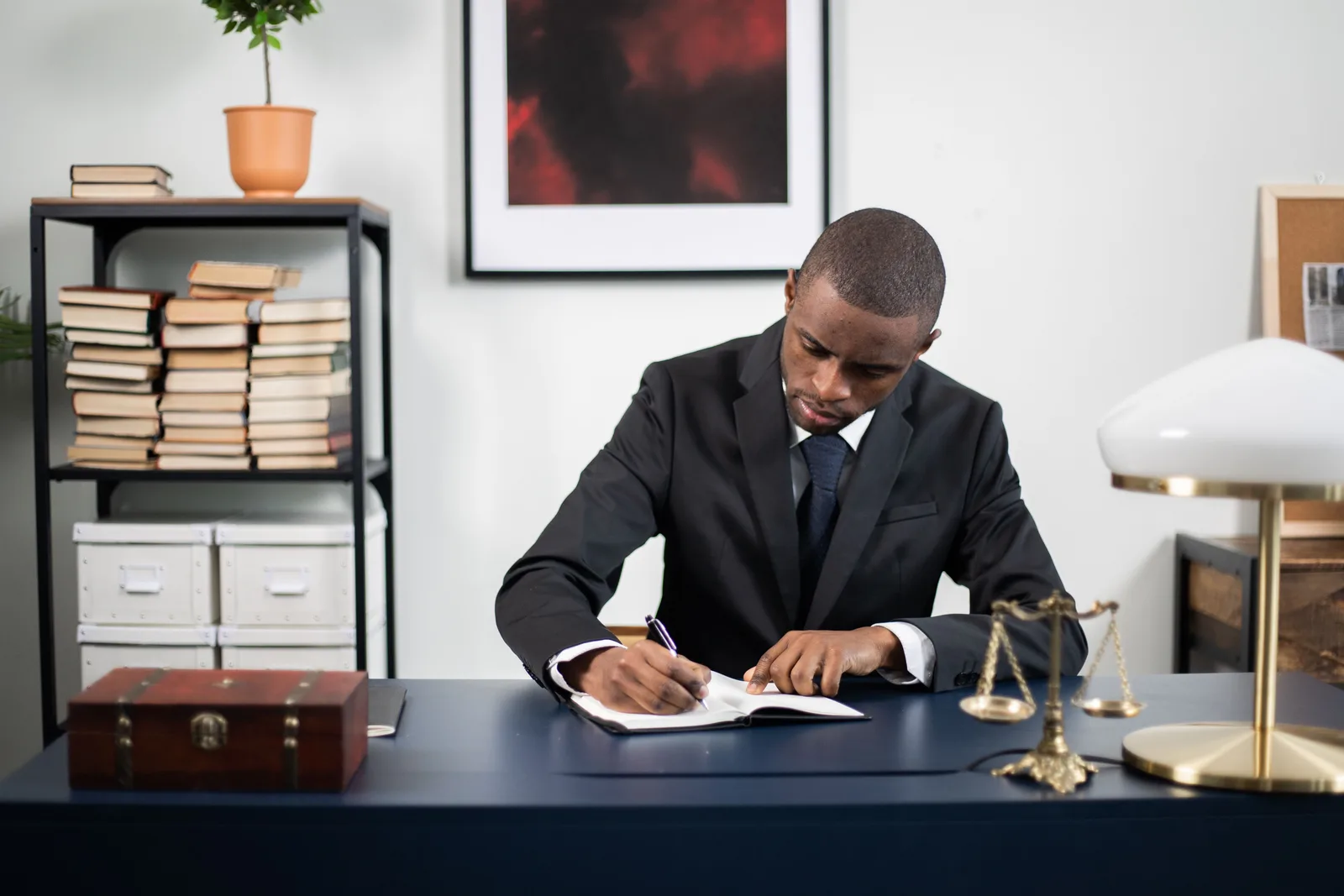 Businessman in formal suit writing notes at office desk with books and scales of justice. Mobile notary services packages: scope, steps, shapes