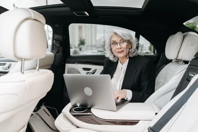 Senior businesswoman using laptop inside a luxury car with modern interior. A mobile notary quote template: twelve fields and what each one prevents